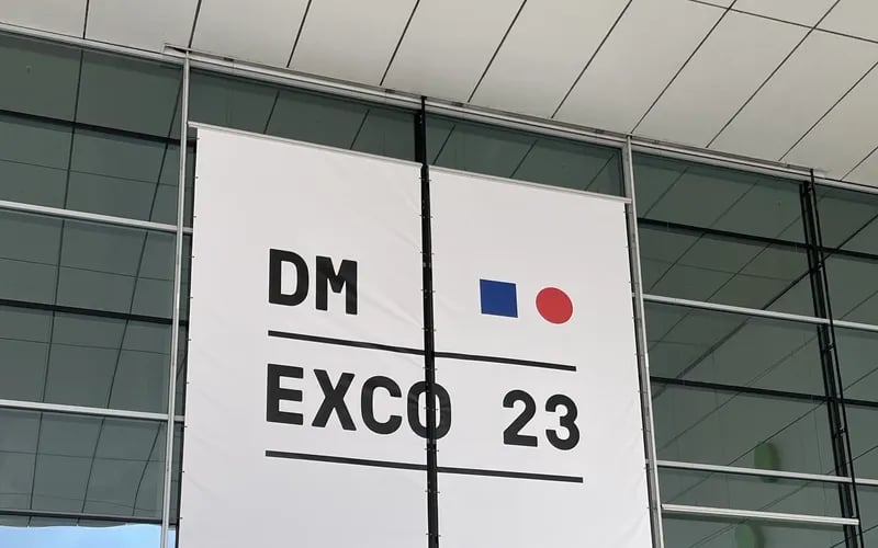 Ein Banner mit dem Schriftzug DMEXCO 23 an der Glasfassade des Messegeländes.