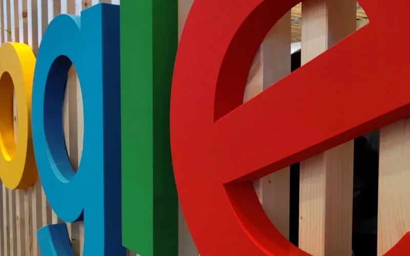 Das Google-Logo als bunte Buchstabenplastik vor einer Holzwand.